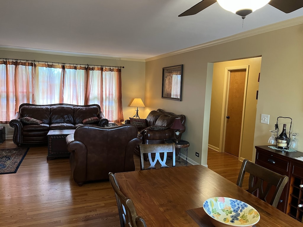 dining room with crown molding, ceiling fan, and wood finished floors