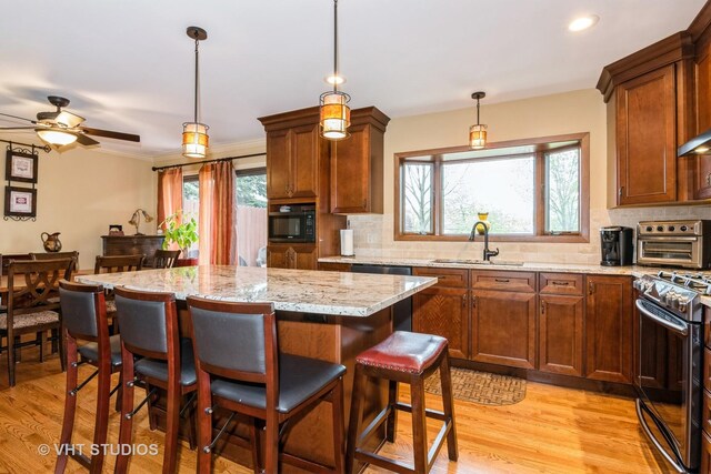 2N305 Mildred Ave, Glen Ellyn, IL 60137 - kitchen featuring a sink, gas range, backsplash, black microwave, and light wood-type flooring
