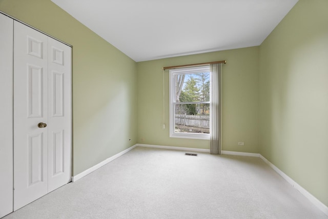 unfurnished bedroom featuring light carpet, visible vents, and baseboards