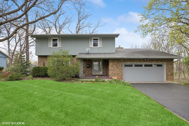 traditional-style home with brick siding, an attached garage, driveway, and a front yard