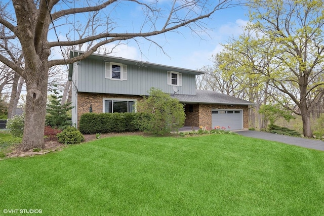 view of front of house with brick siding, an attached garage, driveway, and a front yard