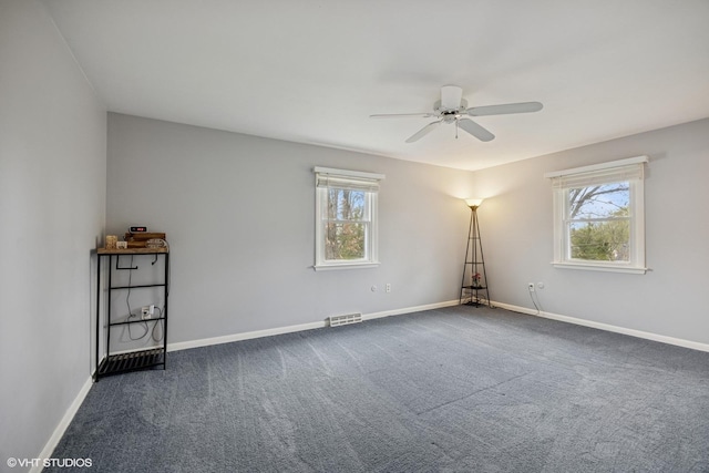 unfurnished room with baseboards, plenty of natural light, a ceiling fan, and visible vents