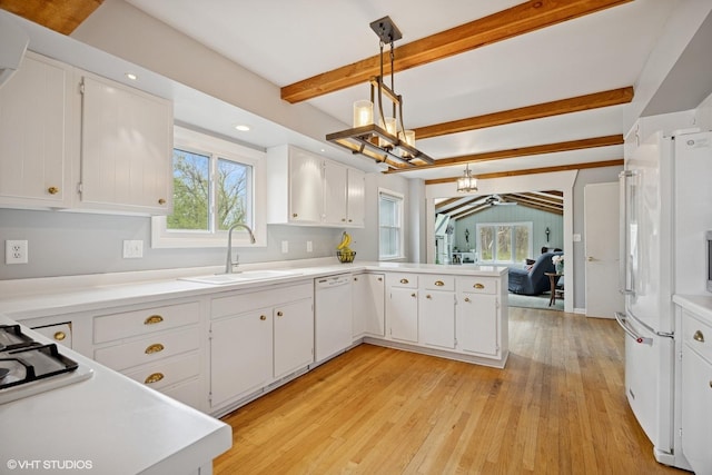 kitchen featuring light wood-type flooring, beam ceiling, a sink, white cabinets, and white appliances