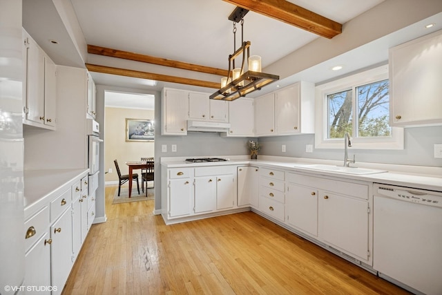 kitchen featuring beam ceiling, a sink, light wood finished floors, white appliances, and under cabinet range hood
