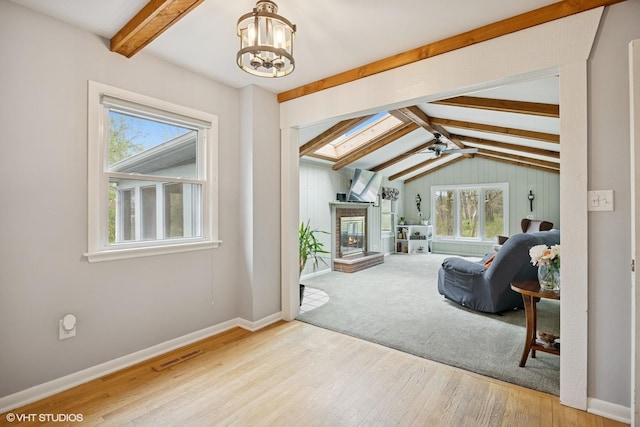 living room with baseboards, a chandelier, plenty of natural light, and wood finished floors