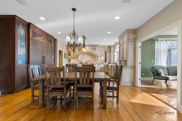 dining area featuring light wood finished floors, an inviting chandelier, baseboards, and recessed lighting