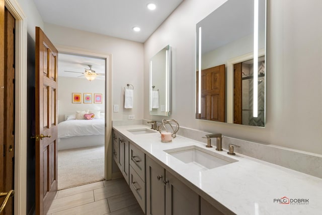 bathroom featuring connected bathroom, a sink, double vanity, and recessed lighting
