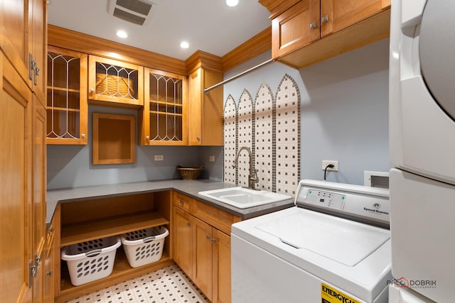 laundry area featuring visible vents, a sink, cabinet space, and washer / dryer