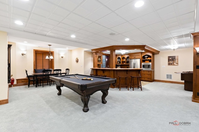 recreation room featuring light colored carpet, baseboards, and bar