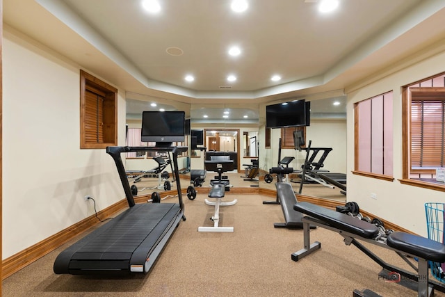 exercise area with carpet floors, baseboards, recessed lighting, and a raised ceiling