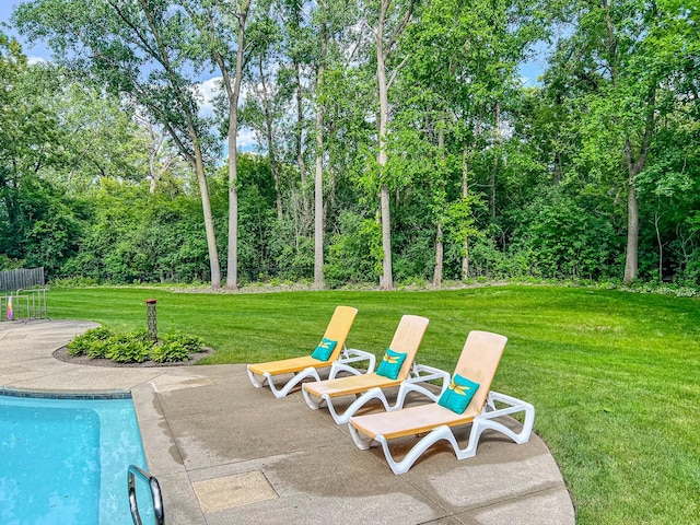 outdoor pool featuring a patio area and a lawn
