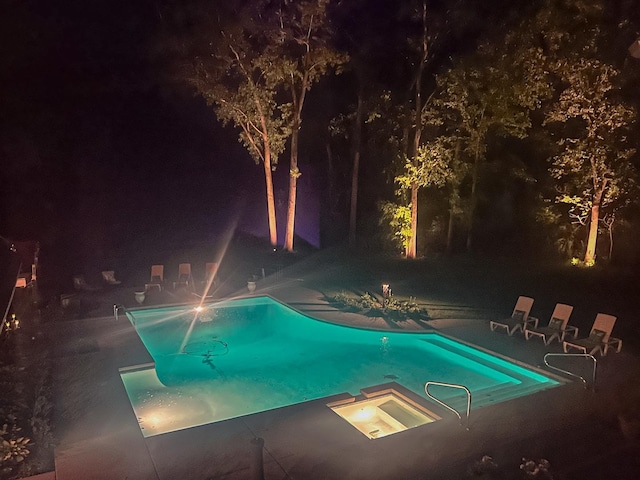 pool at twilight with an outdoor pool and a patio