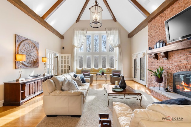living area with high vaulted ceiling, wood finished floors, beamed ceiling, baseboards, and a brick fireplace