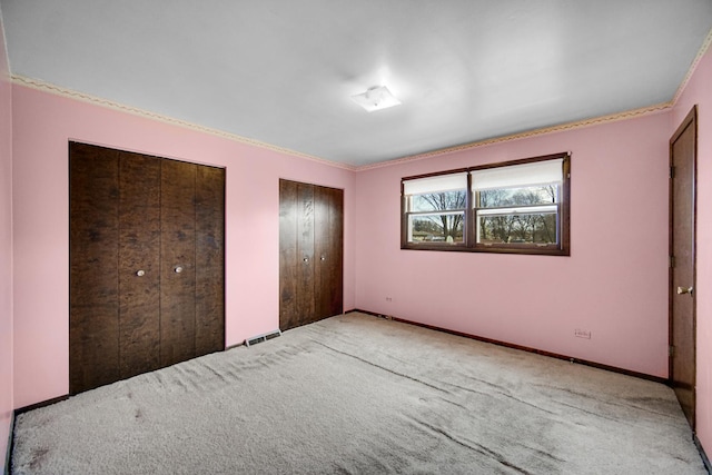 16157 Ozark Ave, Tinley Park, IL 60477 - unfurnished bedroom with two closets, crown molding, baseboards, and carpet