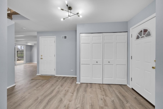unfurnished bedroom featuring baseboards, a closet, wood finished floors, and a chandelier