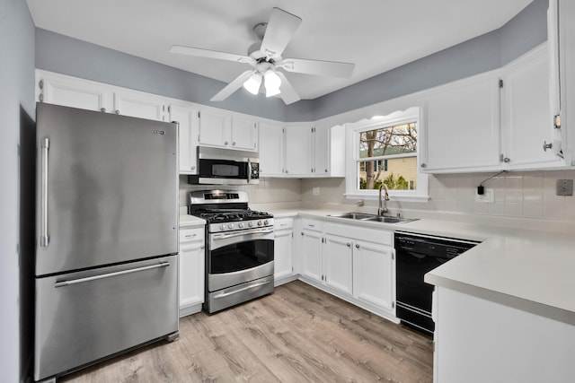 kitchen featuring a sink, appliances with stainless steel finishes, tasteful backsplash, and light countertops