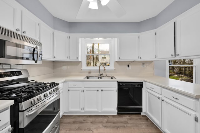 kitchen with light countertops, stainless steel appliances, a sink, and tasteful backsplash