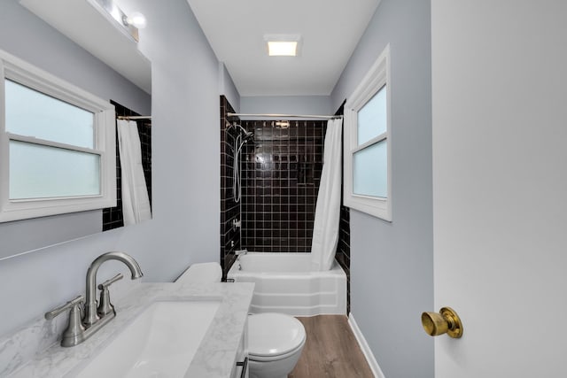 full bath featuring toilet, wood finished floors, shower / bath combo, and vanity