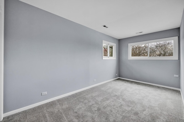 unfurnished room featuring visible vents, carpet flooring, and baseboards