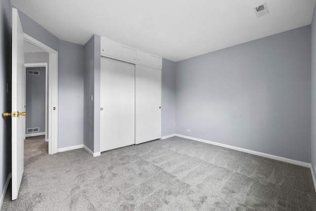 unfurnished bedroom featuring carpet floors, baseboards, visible vents, and a closet