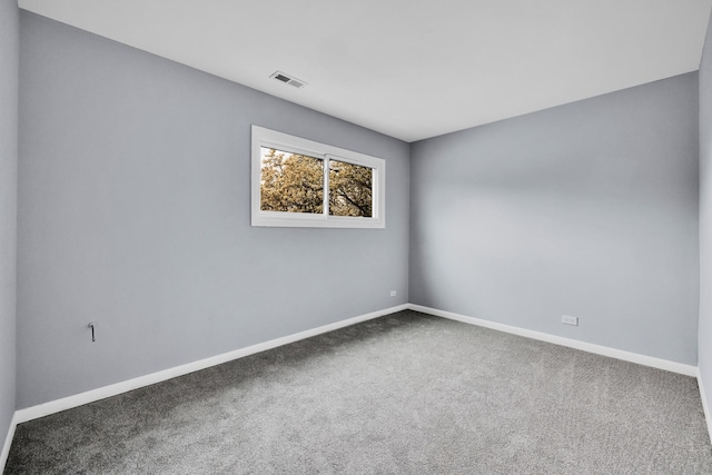carpeted spare room featuring baseboards and visible vents