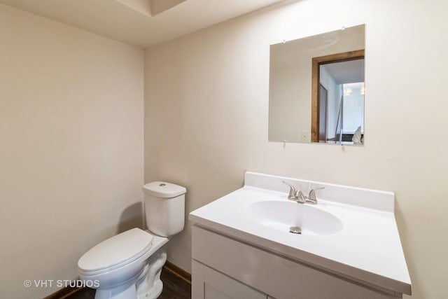 bathroom with vanity, toilet, and wood finished floors