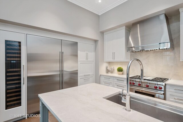 435 N Michigan Ave Unit 401, Chicago, IL 60611 - kitchen with crown molding, premium appliances, backsplash, white cabinets, and wall chimney exhaust hood