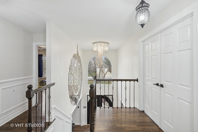 7267 Southwick Dr, Frankfort, IL 60423 - hallway with dark wood finished floors, an upstairs landing, a decorative wall, wainscoting, and a chandelier