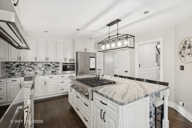 7267 Southwick Dr, Frankfort, IL 60423 - kitchen featuring under cabinet range hood, appliances with stainless steel finishes, light stone countertops, and white cabinetry