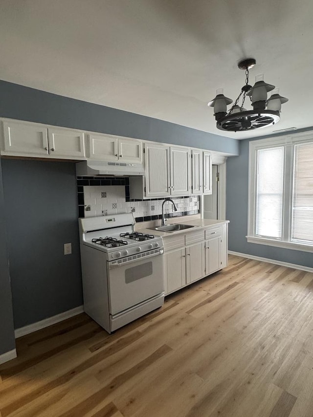 554 Spring St, Aurora, IL 60505 - kitchen with white cabinetry, gas range gas stove, under cabinet range hood, and a sink