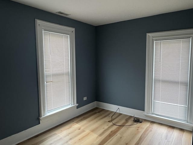 554 Spring St, Aurora, IL 60505 - spare room featuring baseboards, wood finished floors, and visible vents
