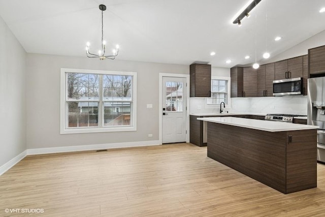 23726 N Overhill Dr, Lake Zurich, IL 60047 - kitchen featuring stainless steel appliances, baseboards, dark brown cabinetry, a chandelier, and light countertops