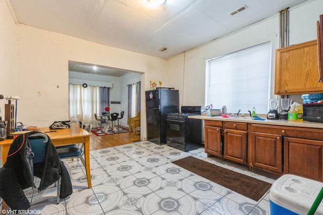 1733 N Keating Ave, Chicago, IL 60639 - kitchen with black appliances, an office area, light countertops, brown cabinetry, and light wood-style flooring