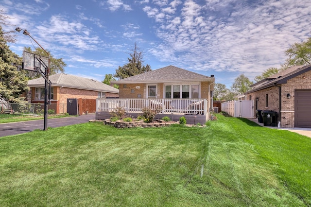 view of front of property with a gate, brick siding, a deck, and asphalt driveway