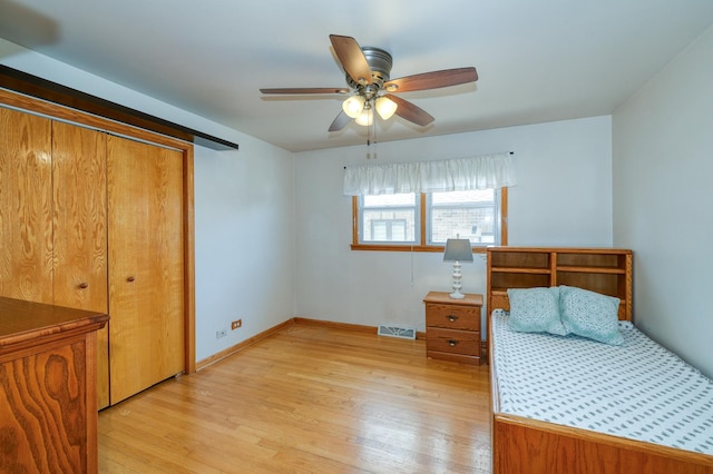 bedroom featuring light wood-style flooring, baseboards, ceiling fan, and a closet