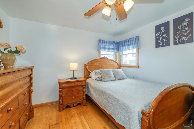 bedroom featuring light wood-style flooring, a ceiling fan, and baseboards