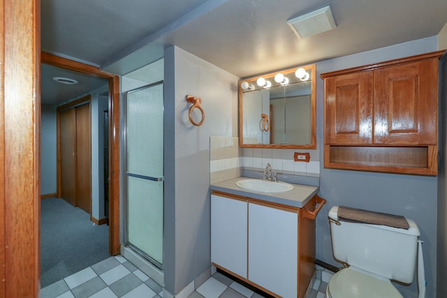 bathroom featuring vanity, a shower stall, toilet, and tasteful backsplash
