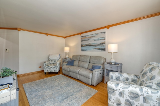 living room with ornamental molding, wood finished floors, and baseboards