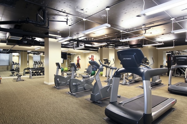 exercise room with carpet flooring and baseboards