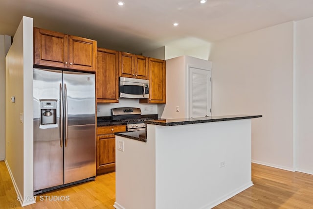 kitchen with stainless steel appliances, light wood-style floors, brown cabinets, recessed lighting, and a kitchen island