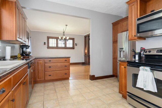 316 E Pierce St, Pontiac, IL 61764 - kitchen featuring appliances with stainless steel finishes, brown cabinets, dark countertops, and a chandelier