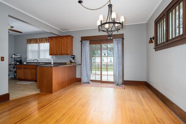 316 E Pierce St, Pontiac, IL 61764 - kitchen featuring brown cabinets, a chandelier, healthy amount of natural light, dark countertops, and ornamental molding