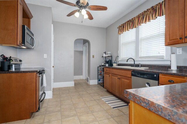 316 E Pierce St, Pontiac, IL 61764 - kitchen with stainless steel appliances, arched walkways, a sink, a ceiling fan, and brown cabinets