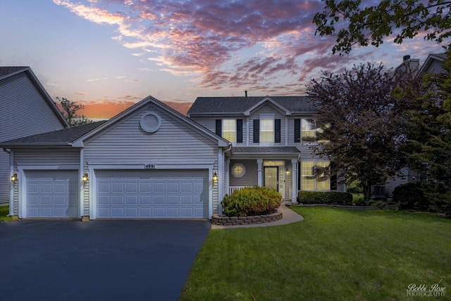 traditional-style home featuring driveway, a front lawn, and a garage