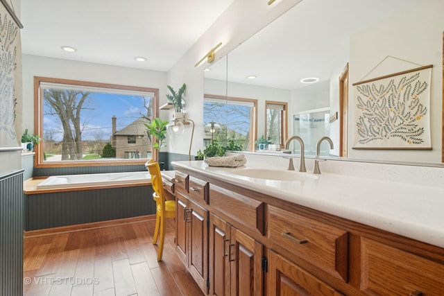 23114 W N Lakewood Ln, Lake Zurich, IL 60047 - bathroom featuring healthy amount of natural light, vanity, wood finished floors, a garden tub, and recessed lighting
