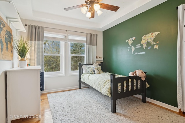23114 W N Lakewood Ln, Lake Zurich, IL 60047 - bedroom with wood finished floors, a raised ceiling, baseboards, and ceiling fan