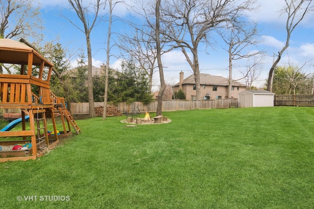 23114 W N Lakewood Ln, Lake Zurich, IL 60047 - view of yard with a playground, a fire pit, a storage unit, and an outbuilding