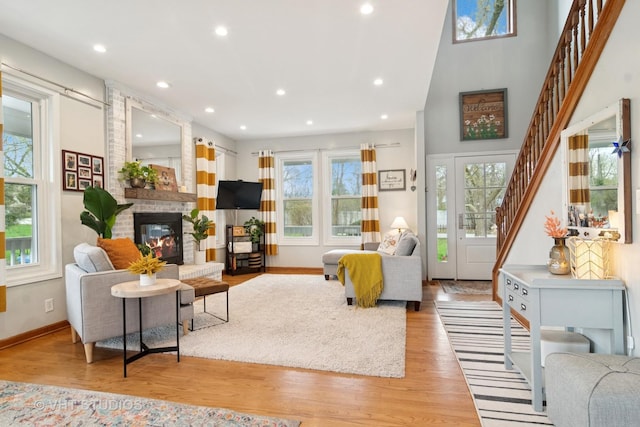 23114 W N Lakewood Ln, Lake Zurich, IL 60047 - living room featuring a fireplace, baseboards, light wood-style floors, recessed lighting, and stairway
