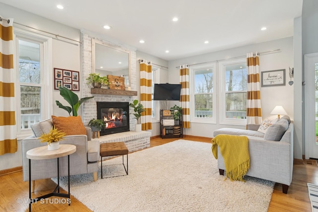 23114 W N Lakewood Ln, Lake Zurich, IL 60047 - living area with wood finished floors, a brick fireplace, baseboards, and recessed lighting