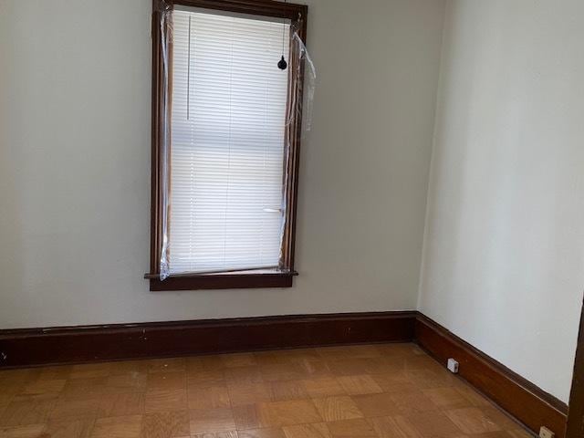 empty room featuring tile patterned floors and baseboards
